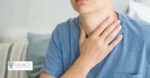 Person holding their throat showing discomfort caused by alcohol-related throat irritation
