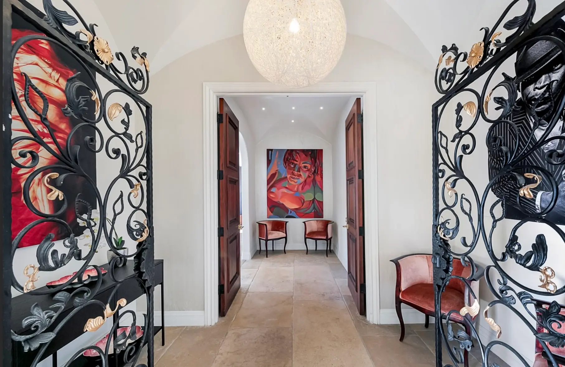Elegant wrought iron doors opening into a luxury Los Angeles mental health retreat with modern art and refined interior design