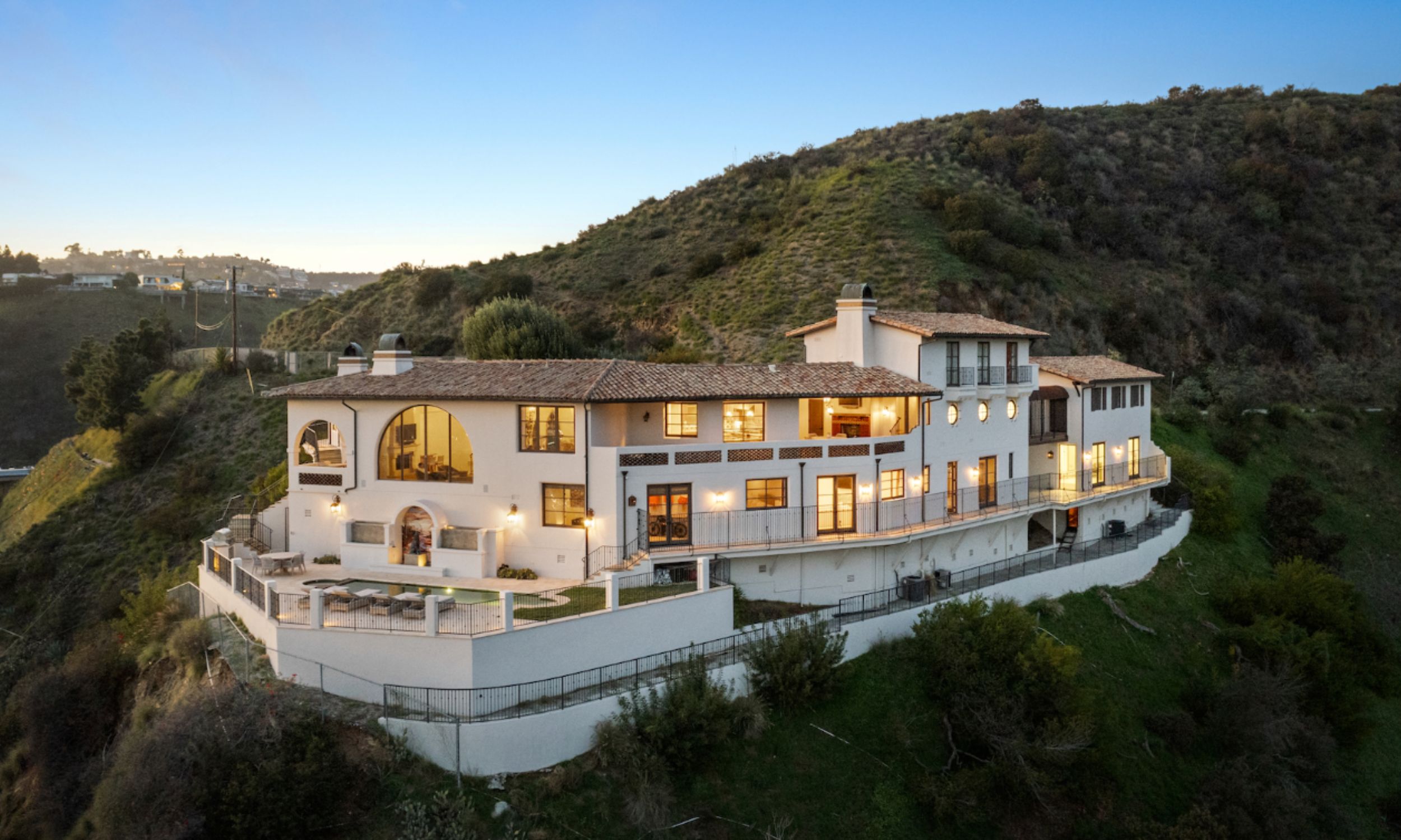 The image depicts a serene outdoor aerial view of a luxury rehab facility in Los Angeles on the Hollywood Hills, featuring a comfortable and private recovery space surrounded by lush palm trees, creating a supportive environment for individuals seeking treatment for addiction. This peaceful setting is ideal for patients to relax and engage in group therapy sessions as part of their recovery journey.